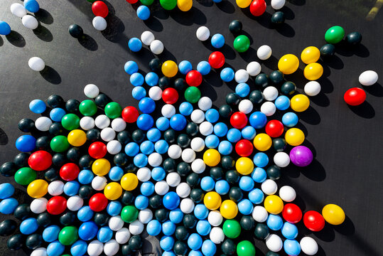 Colorful plastic balls bouncing on a black surface