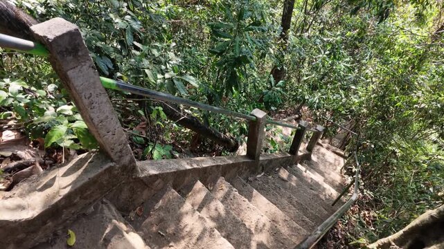 steep stone stairs descending into lush jungle forest at Sekumpul waterfall in Bali, rustic path with metal railing, trekking adventure, tropical hiking trail, outdoor exploration, travel lifestyle