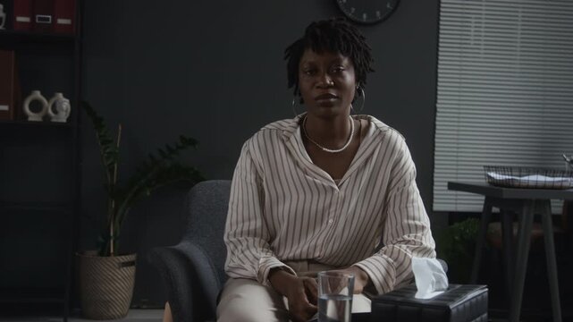 Portrait of serious young adult African American woman sitting during psychological counseling session. Footage suited for mental health awareness and psychotherapy campaigns