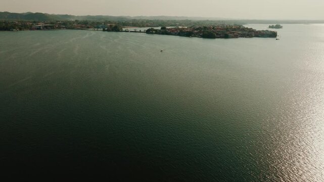 Aerial view of Flores Island in Lake Peten Itza, featuring historic buildings and lush greenery surrounded by the calm waters of the lake in Flores, Peten Department, Guatemala.