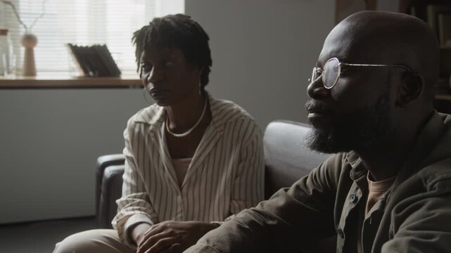 African American couple sitting on couch and holding hands during therapy session. Footage suited for couples counseling, mental health services and family psychology campaigns