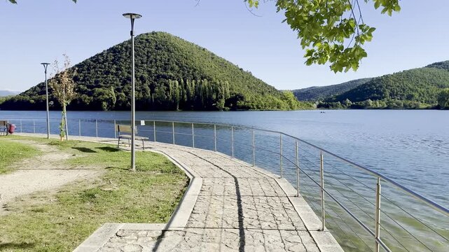 Scenic river walk of Piediluco Lake, Terni Umbria. Lush forest surrounding calm water on an end of summer day in Italy