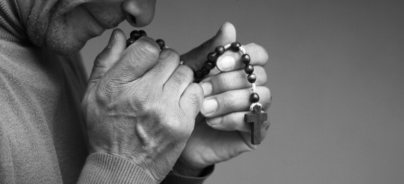 praying to god with hands showing his religious faith with God Caribbean man praying with background with people stock photo stock image