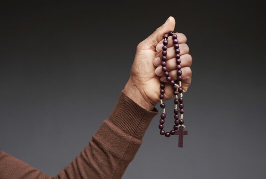 praying to god with hands showing his religious faith with God Caribbean man praying with background with people stock photo stock image