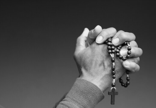 praying to god with hands showing his religious faith with God Caribbean man praying with background with people stock photo stock image