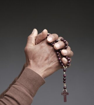 praying to god with hands showing his religious faith with God Caribbean man praying with background with people stock photo stock image