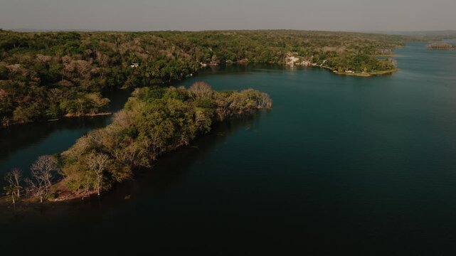 Aerial view of the lush, forested Flores Island surrounded by the calm, deep waters of Lake Peten Itza in Flores, Peten Department, Guatemala.