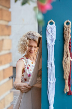 Thoughtful mature woman examining handmade textile apron at local craft shop in Spain
