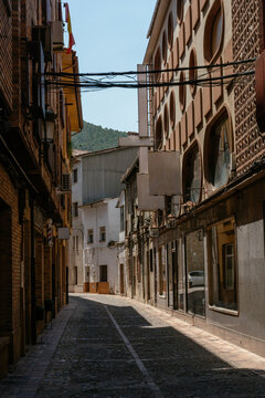 Narrow cobblestone street with traditional buildings in quiet provincial Spanish town