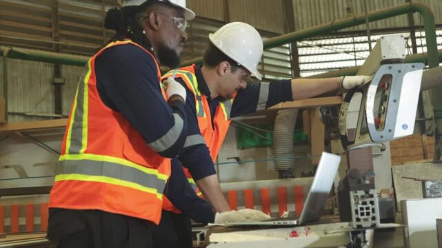 Two carpenters safety gear ensure maximum safety operating machinery experienced carpenter controls the wood cutting equipment designs furniture processed plywood wood product manufacturing plant.