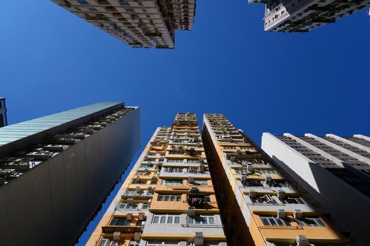 Hong Kong high density public housing residential estate. Street view looking up. Apartment buildings in Mong Kok neighborhood of Kowloon, Hong Kong.