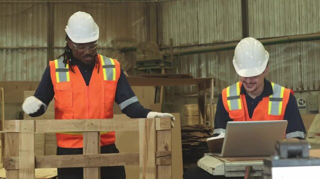 Team carpenters measures processed lumber tape measure ensure the lengths meet specifications records the data production pallets platforms used stacking storing transporting goods  factory warehouse.