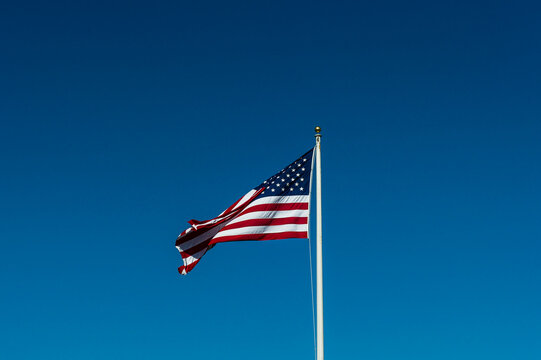 View of the American flag waving against a clear blue sky in Vancouver, British Columbia, Canada.