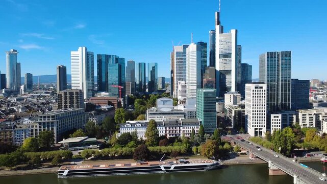 Aerial pullback from Frankfurt financial district revealing skyscrapers, a busy road bridge, traffic and the Main River. Filmed September 25, 2026.