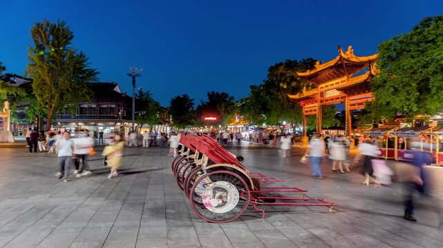 Busy Traditional Chinese Street at Night with Illuminated Archway and Pedestrians in China