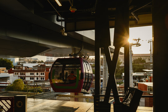 View of the Teleferico de Uruapan cable car cabin arriving at the station during golden hour with urban buildings in the background in Uruapan, Michoacan, Mexico.