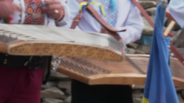 A cinematic video showing male hands skillfully striking the strings of an
 acoustic hammered dulcimer with wooden mallets. 
 