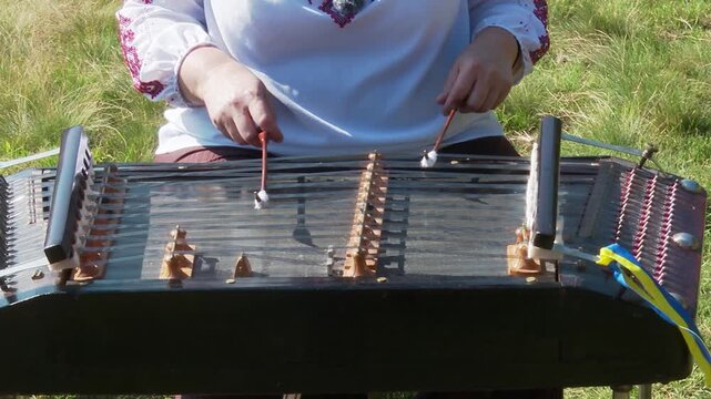 Female Musician Hands Playing Traditional Folk Dulcimer Instrument. Cinematic video of a woman&rsquo;s hands expertly hitting the strings of an acoustic
 hammered dulcimer with wooden mallets
