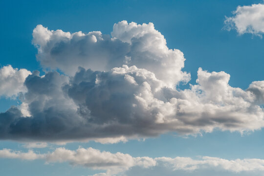 View of fluffy white cumulus clouds drifting across a vibrant blue sky over the city in Novi Sad, Vojvodina, Serbia.