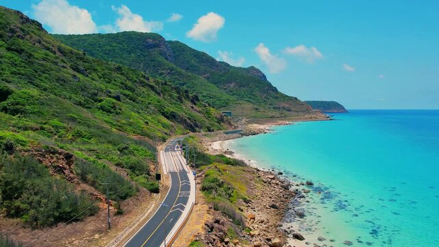 Aerial view of scenic coastal road and turquoise sea in Con Dao
