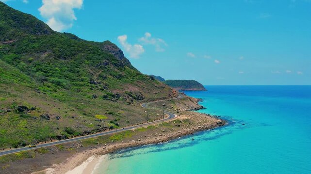 Drone approach to winding S-shaped coastal road in Con Dao
