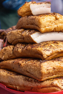 View of stacked pieces of traditional smoked pork fat with a golden-brown crust and thick white layers of lard in Vilnius, Vilnius County, Lithuania.
