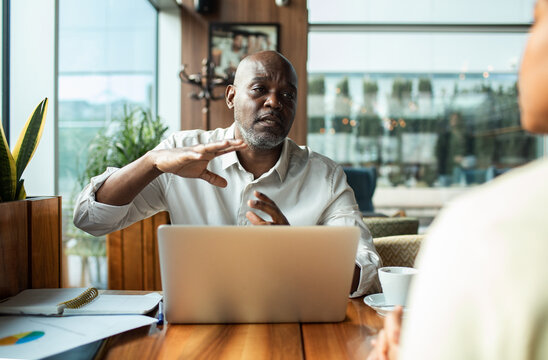 Man explaining to client during cafe meeting