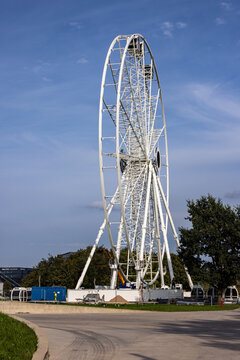 View of the white Ferris wheel structure under a clear blue sky in an open area in Kaunas, Kaunas County, Lithuania.
