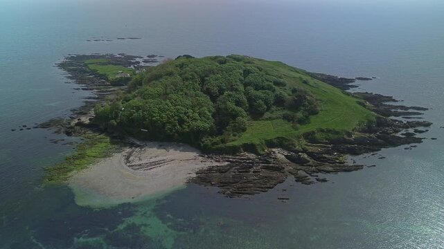Aerial view of Looe Island surrounded by rocky coastline and clear sea water in Looe, England, United Kingdom.