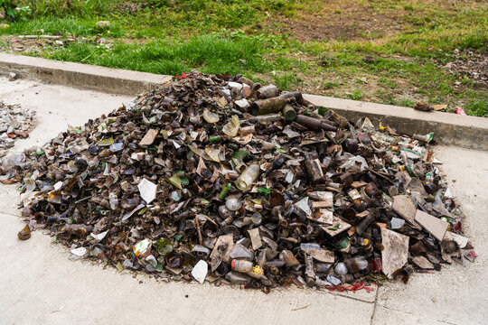 View of a large pile of broken glass bottles and debris collected on a concrete surface in Wewak, East Sepik Province, Papua New Guinea.