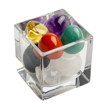 Assorted polished gemstones in a clear glass cube isolated on white