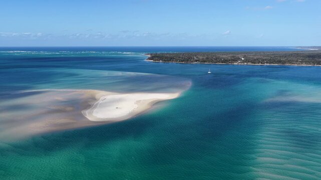 Aerial view of a white sandbank surrounded by turquoise waters in Moreton Bay near the coastline of North Stradbroke Island at Amity Point, Queensland, Australia.