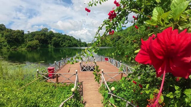Boga Lake view framed with red flowers in Bandarban Bangladesh