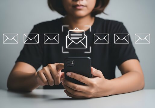 Woman holding smartphone interacting with digital email icons floating above touchscreen interface
