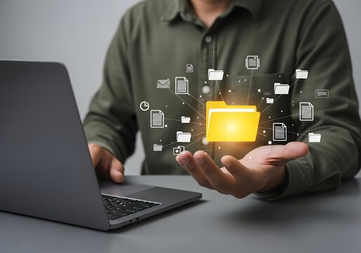 Man using laptop with glowing virtual folder and document icons floating above his open hand