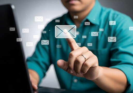 Person touching a digital email icon floating above a laptop screen for communication and messaging