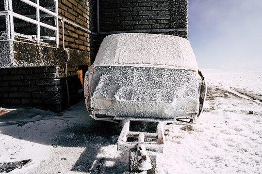 View of the frozen Golyam Kademliya Shelter covered in rime ice and snow next to a brick wall in Stara Zagora, Bulgaria.