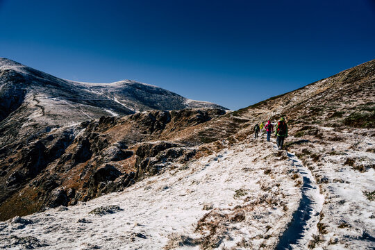 View of hikers walking along a snowy mountain trail near Golyam Kademliya Shelter in Stara Zagora, Bulgaria.