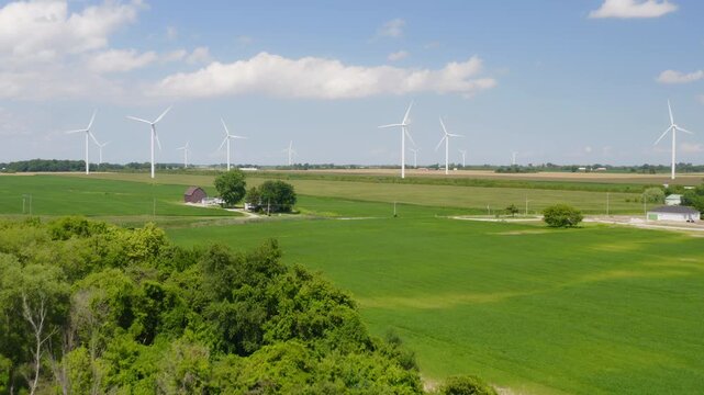 Rising aerial reveal of wind turbines in open fields