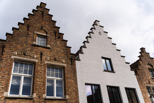 View of historic brick step-gabled houses with traditional architecture in Bruges, Flanders, Belgium.