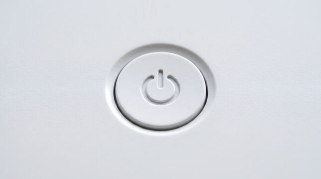 A minimalist white circular power button with an embossed power symbol on a plain surface representing technology and activation