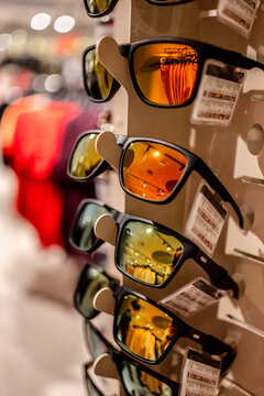 Colorful sunglasses displayed on a rack in a retail store