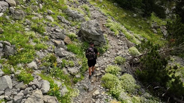 Aerial view of lone hiker on rocky alpine trail in Albania