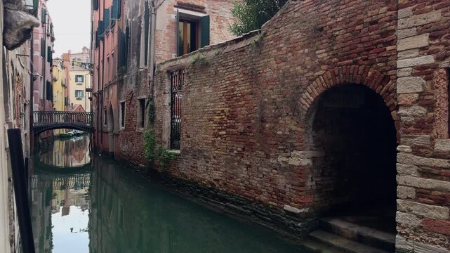 Solitary Walker Crossing Stone Bridge Over Venice Canal
