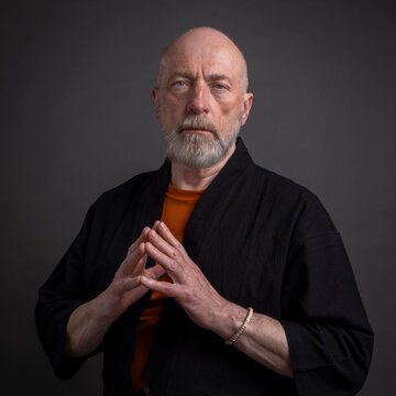 portrait of a serious, bearded senior man wearing a kimono