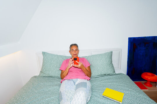 Using smartphone while relaxing in bed