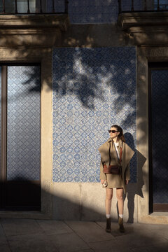 Woman standing against traditional blue tiles in Porto