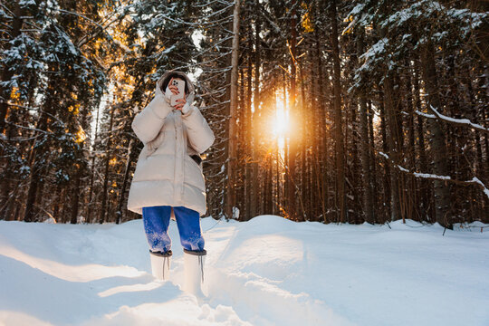 A Woman Searches, Uses A Phone In A Snowy Winter Forest
