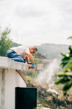 Woman Works on Roof in Warm Weather