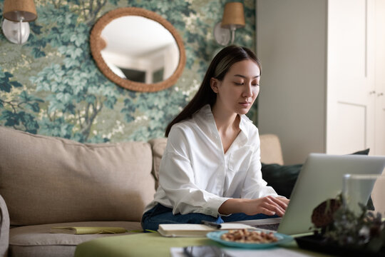 Asian woman using laptop for work at home